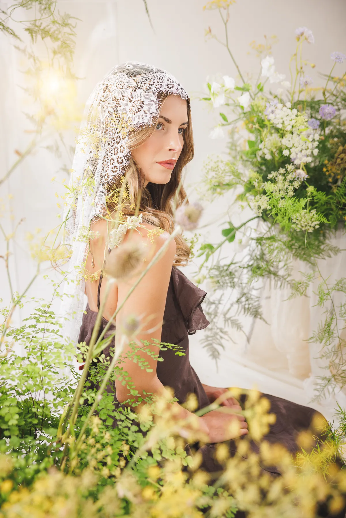 Guest in a lace veil seated among tall wildflower stems — Let Them Eat Flowers